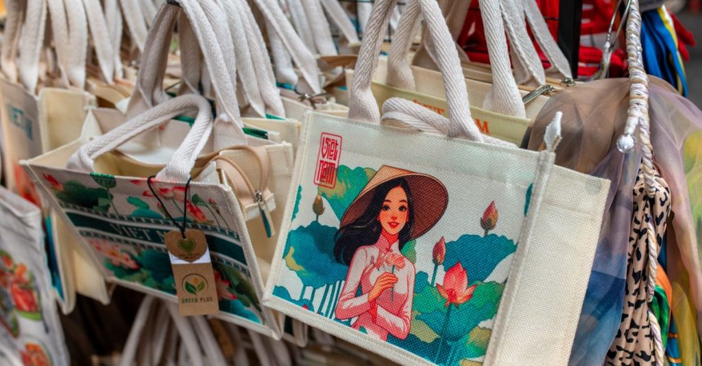 Vibrant canvas tote bags with artistic designs on display in a market.