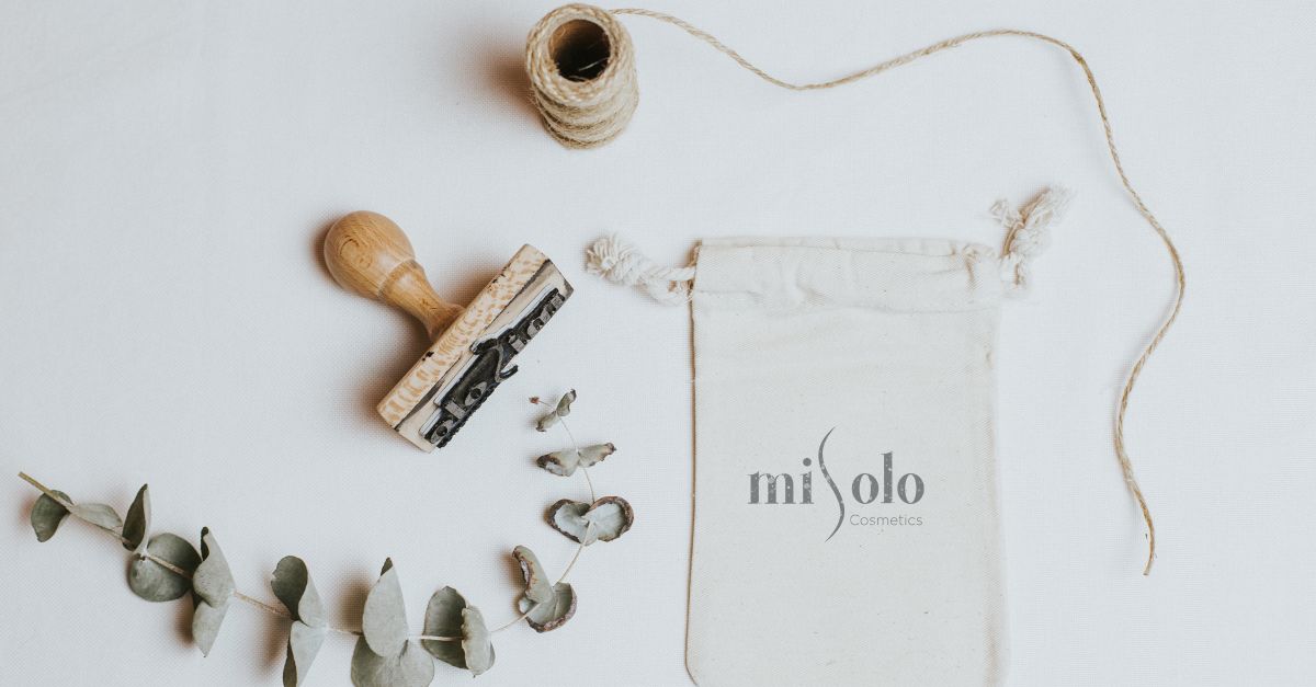 Organic cosmetic packaging with natural elements and stamp on white background.