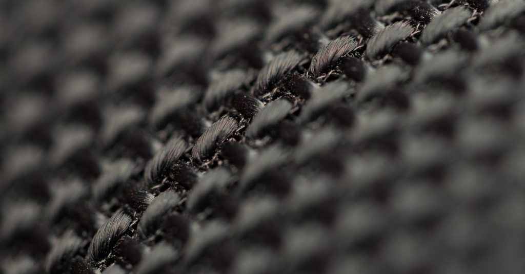 Detailed view of black woven fabric showcasing intricate texture and weave pattern.
