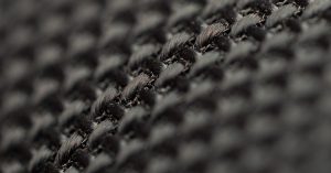 Detailed view of black woven fabric showcasing intricate texture and weave pattern.