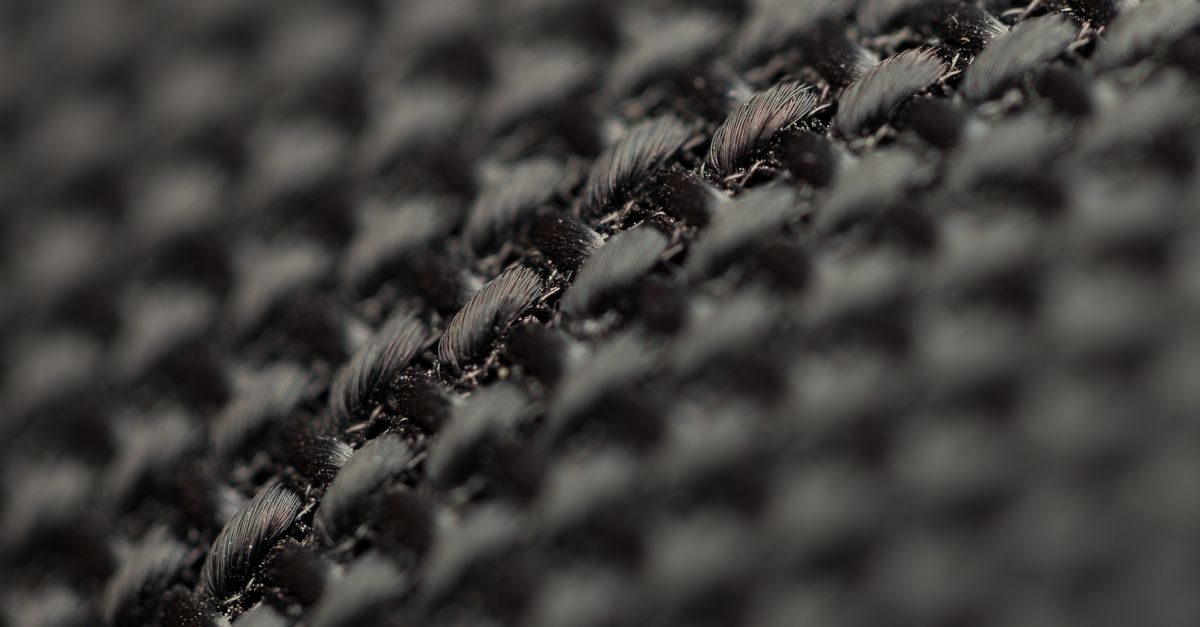 Detailed view of black woven fabric showcasing intricate texture and weave pattern.