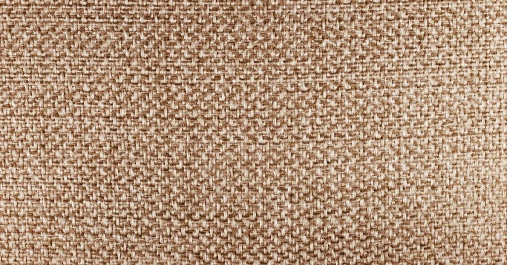 Detailed close-up of beige fabric texture, highlighting its woven pattern.