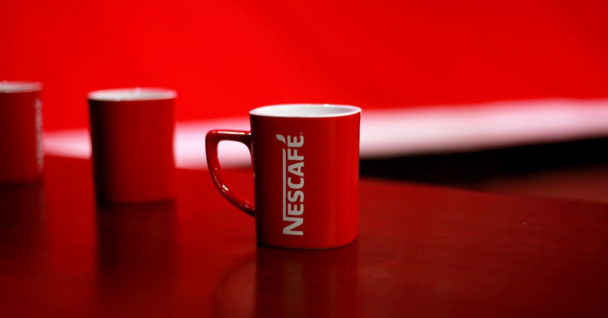 Bright red coffee mug featuring bold branding on a clean studio background.