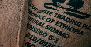 Close-up of burlap sack with Ethiopian coffee logo and text, showcasing texture.