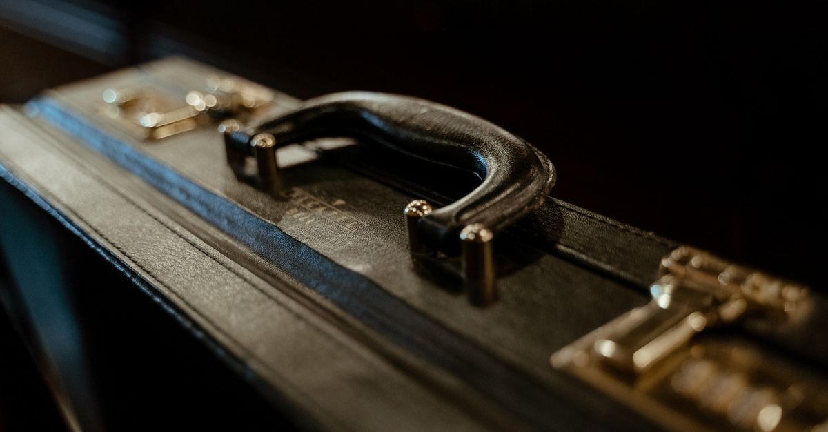 A detailed close-up of a stylish leather briefcase handle, with vintage aesthetic lighting.