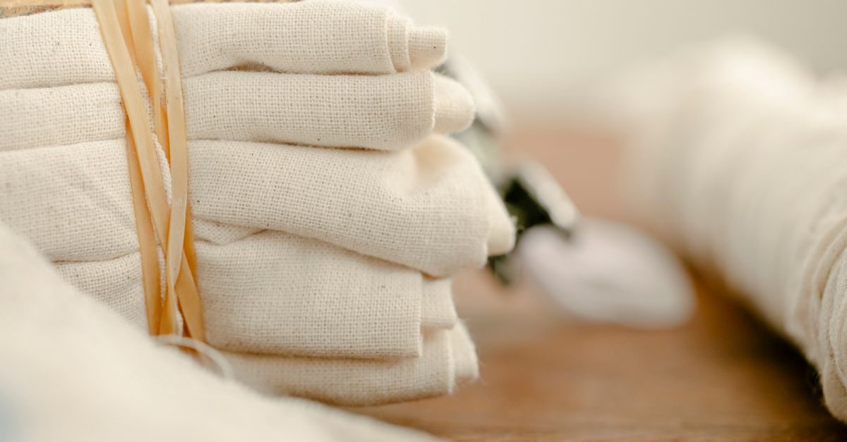 Various ecologically friendly cotton sacks with drawstrings placed on wooden table in light room