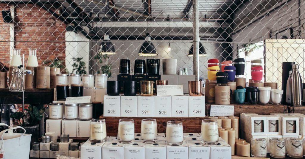 A curated display of handmade candles and home goods on a rustic counter, perfect for cozy interiors.