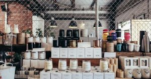 A curated display of handmade candles and home goods on a rustic counter, perfect for cozy interiors.