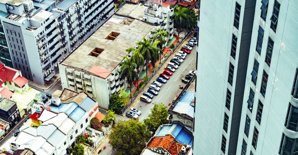 Top view of Kuala Lumpur city with streets, buildings, and parked cars.