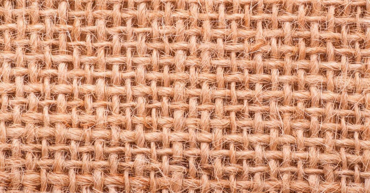 Close-up of a rough jute weave texture showing intricate fibrous pattern.