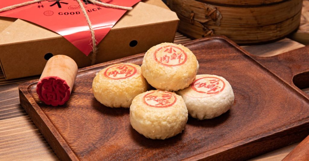 Close-up of traditional Chinese mooncakes with red stamps on a wooden board, ideal for festive occasions.