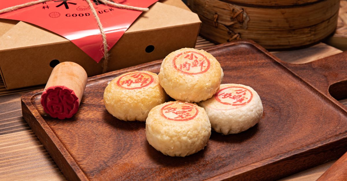 Close-up of traditional Chinese mooncakes with red stamps on a wooden board, ideal for festive occasions.