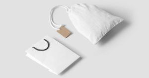Elegant minimalist mockup featuring a white paper and cloth bag on a neutral background.