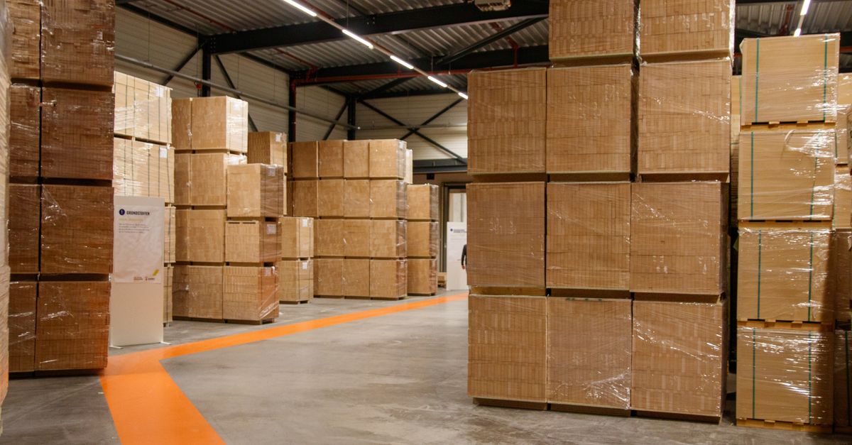 A spacious industrial warehouse filled with stacked cardboard boxes for storage and shipping.