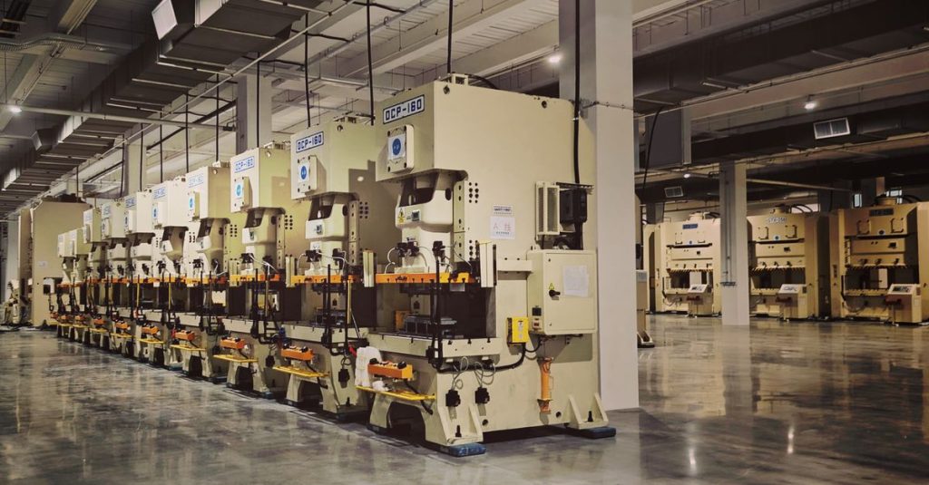 A row of industrial machines on a factory floor, highlighting manufacturing equipment.