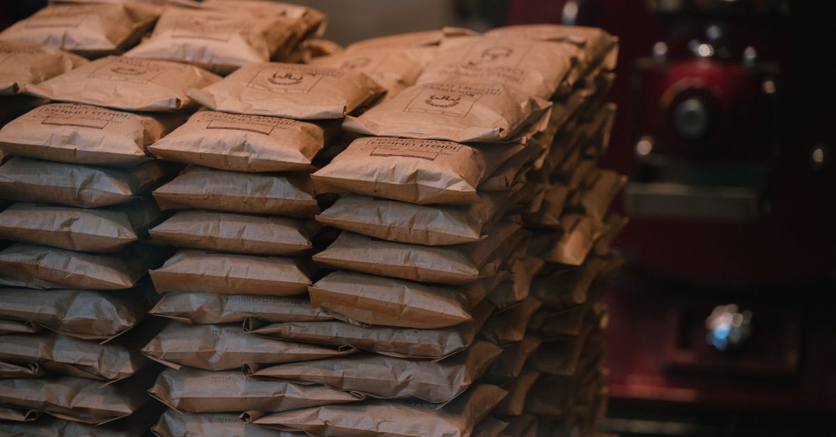 Stacked brown paper packages in an industrial warehouse setting. Perfect for logistics visuals.