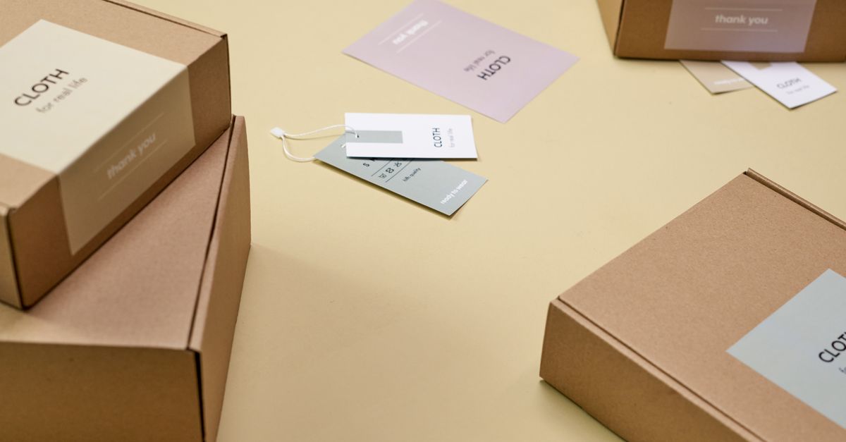 Simple and minimalist cardboard packaging boxes with labels on a yellow surface.
